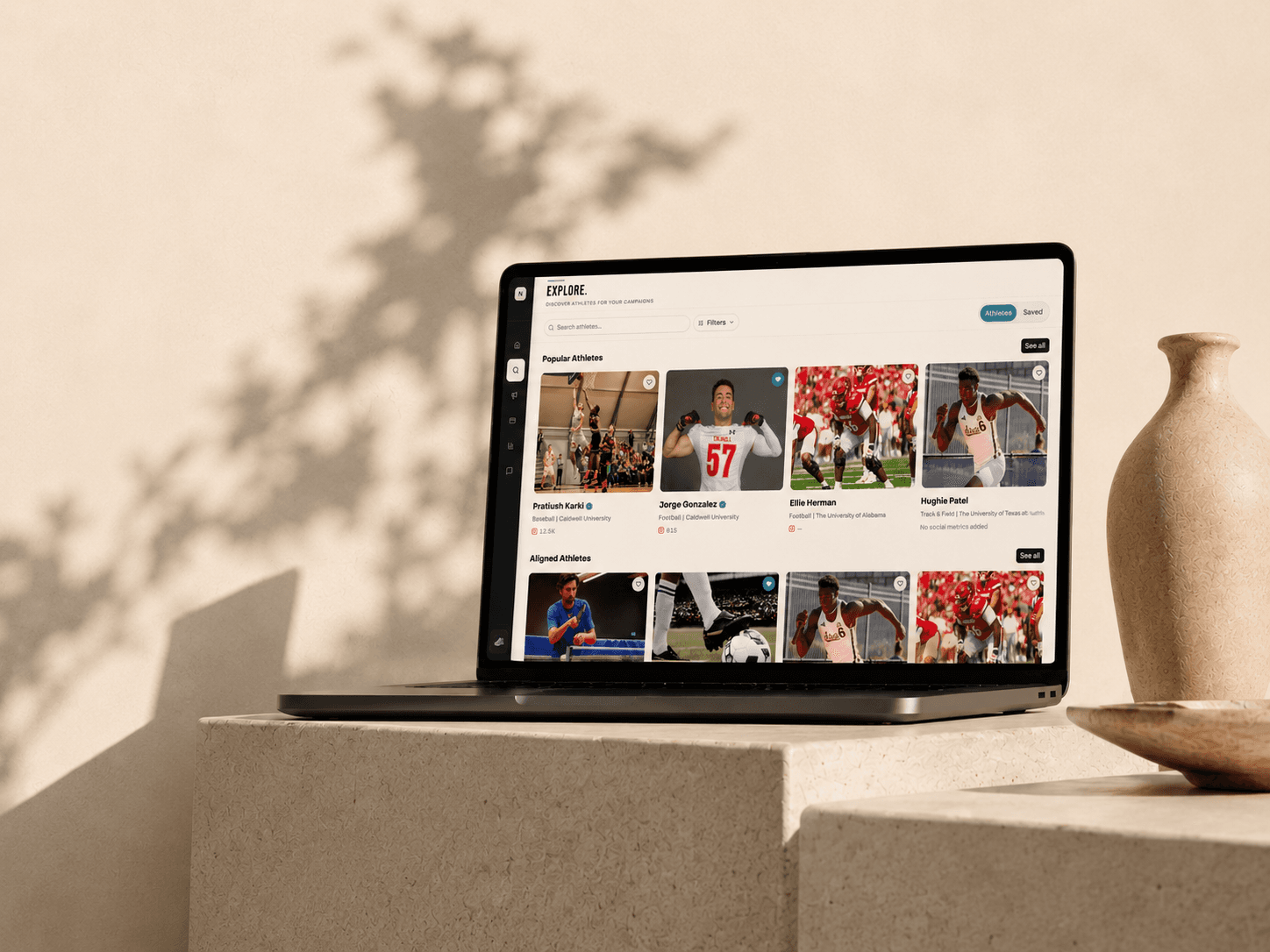 The NILINK athlete explore view open on a laptop, its card grid of athletes lit by afternoon shadow.